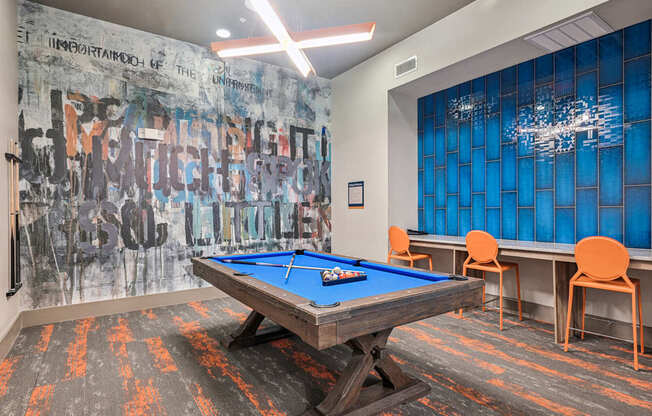 A pool table in a room with a graffiti wall.