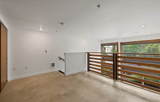 A room with a sliding door and a window with a view of trees.