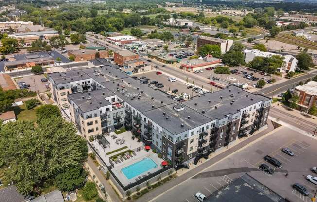 an aerial view of a large building with a pool in the middle of the street