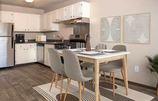 A kitchen with a dining table and chairs.