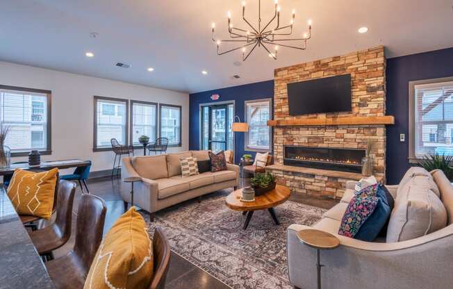 a living room with couches and a fireplace and a chandelier