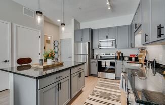 a kitchen with stainless steel appliances and gray cabinets
