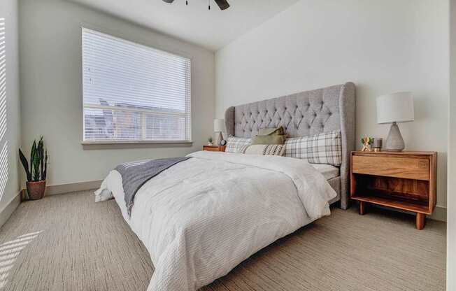 A bedroom with a large bed and a wooden nightstand.