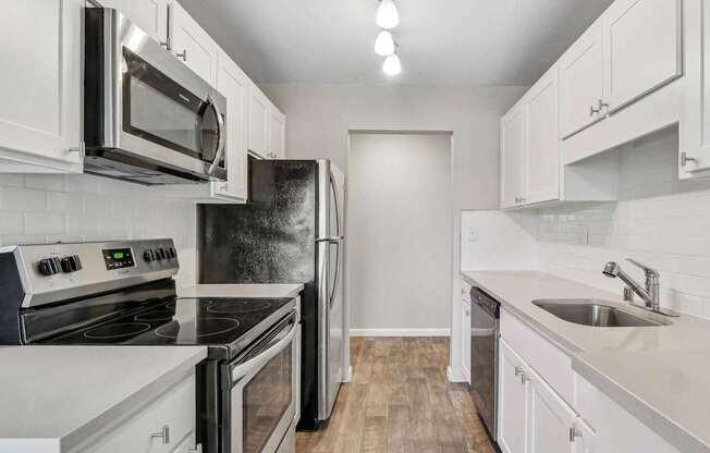 kitchen with white cabinets and stainless steel appliances at Summerwood Apartments, California