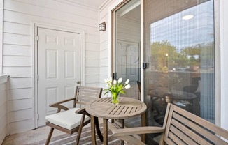 a small porch with a table and chairs and a sliding glass door at Mission Gate, Texas, 75024