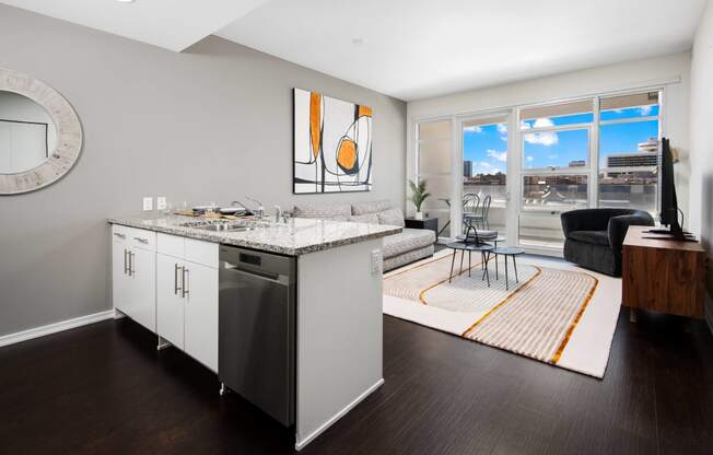 a kitchen with an island and a living room with a large window