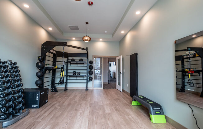 A modern fitness studio here at Van Buren East with free weights, training racks, and open workout space. Large mirrors and sleek flooring create a bright, motivating, and inviting environment.