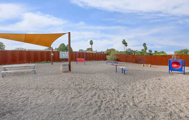 A sandy volleyball court with a net, bench, and ball.