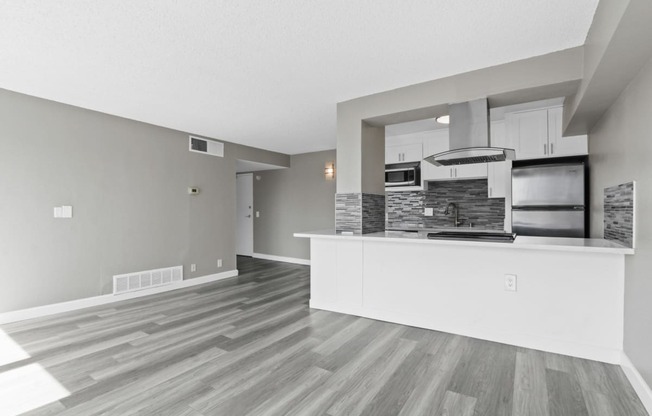 the living room and kitchen of a new home with a kitchen island and