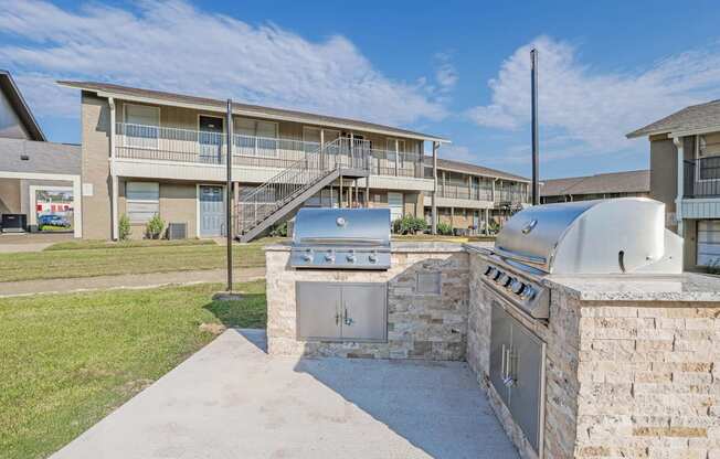 A paved barbeque area with apartment buildings in the background at The Creole Apartments in Shreveport, LA