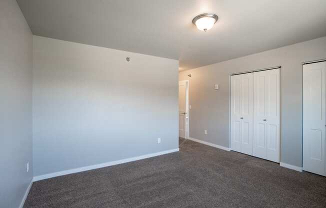 a bedroom with carpet and white doors. Fargo, ND 29 West Apartments