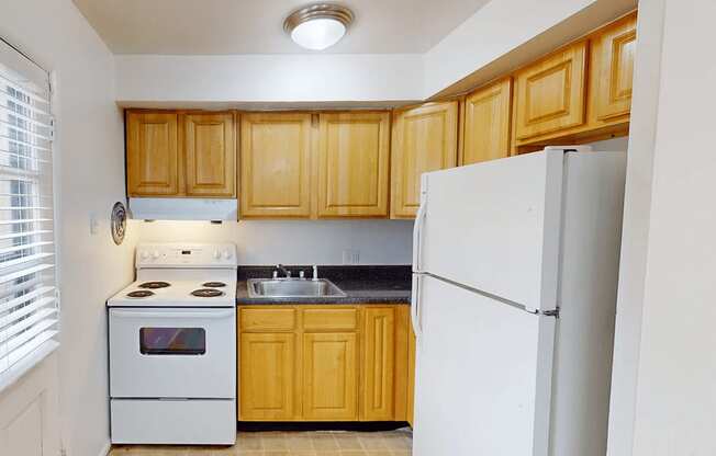 A kitchen with wooden cabinets and a white refrigerator.
