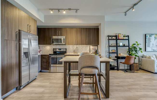 a kitchen with stainless steel appliances and a table with chairs
