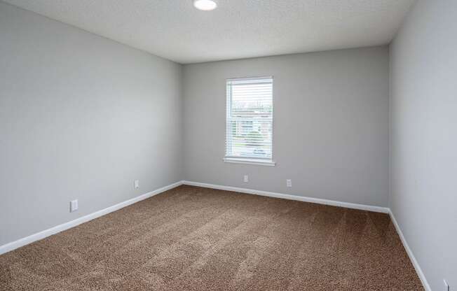 a bedroom with gray walls and a window