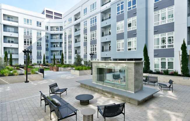 a patio with a fire pit in front of an apartment building