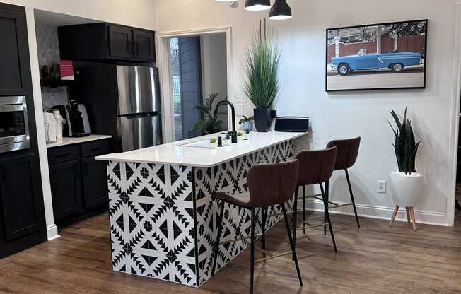 a kitchen with a large white island with a black and white geometric pattern