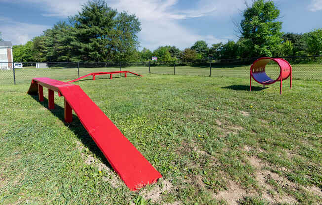 a red bench sitting in the middle of a park