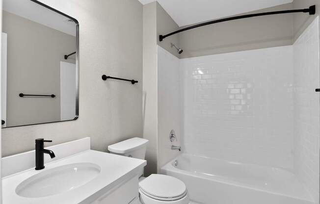 A white bathroom with a sink, toilet, and bathtub.