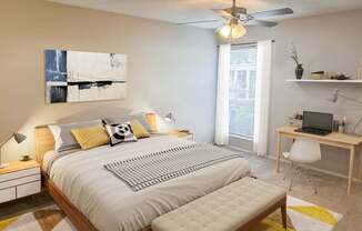 A bedroom with a bed, desk, and chair.