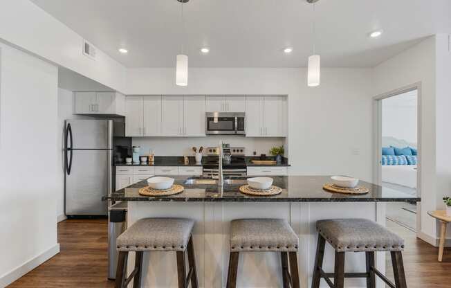 a kitchen with a breakfast bar and stools in front of a kitchen counter top