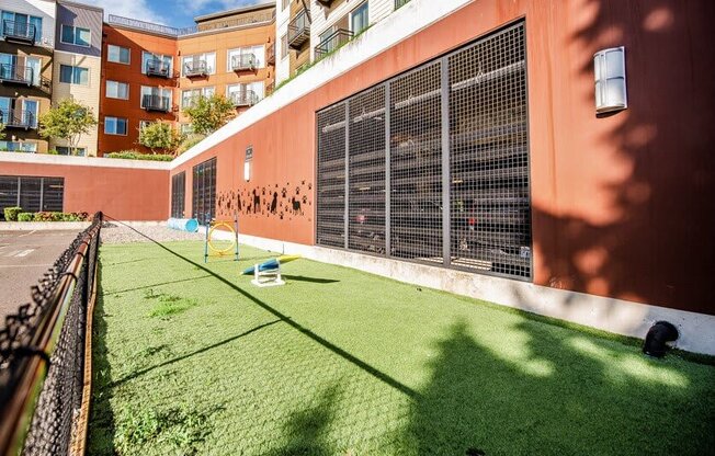 A small grassy area in front of a building with a fence on the left side. at The Platform, Washington, 98032