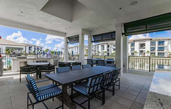 A patio with a table and chairs overlooking a pool.