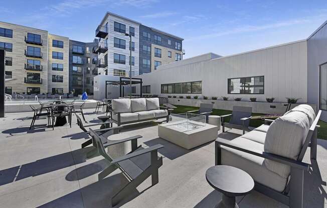 A modern outdoor seating area with concrete furniture and a white building in the background.