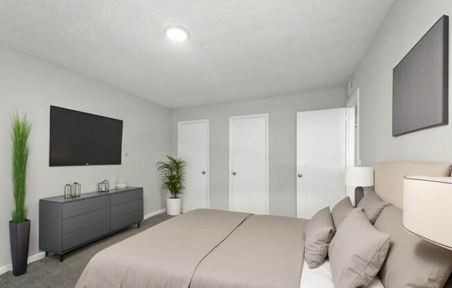 A bedroom with a large bed and a flat screen TV mounted on the wall.