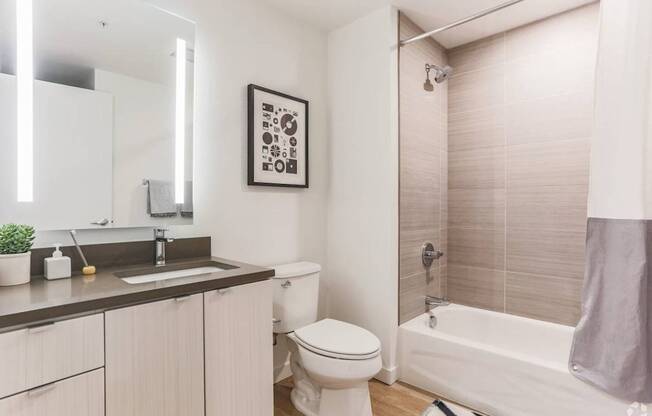 A bathroom with a white toilet, a sink, a bathtub, and a shower.