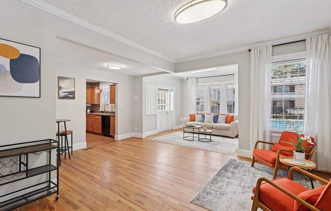 A living room with a red chair and a white couch.