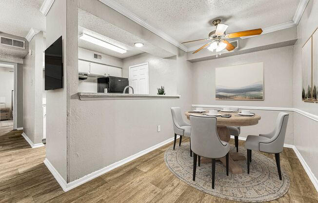 a dining room with a table and chairs and a ceiling fan