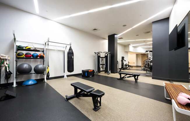 a gym with weights and other equipment on the floor and a tv