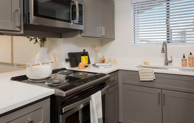 a kitchen with gray cabinets and white countertops