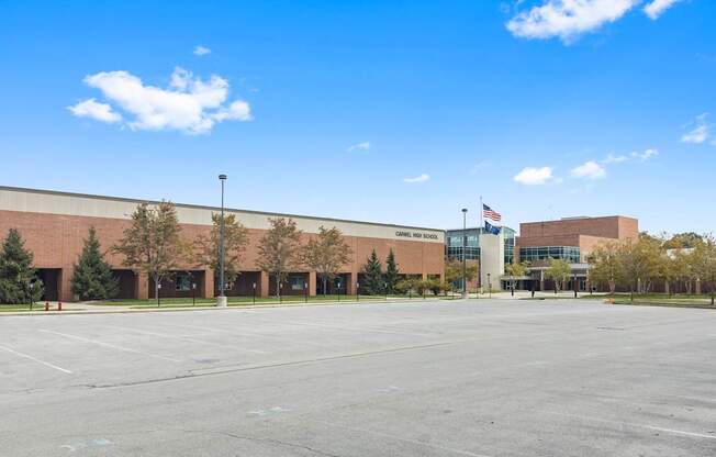 an empty parking lot in front of a building with an flag