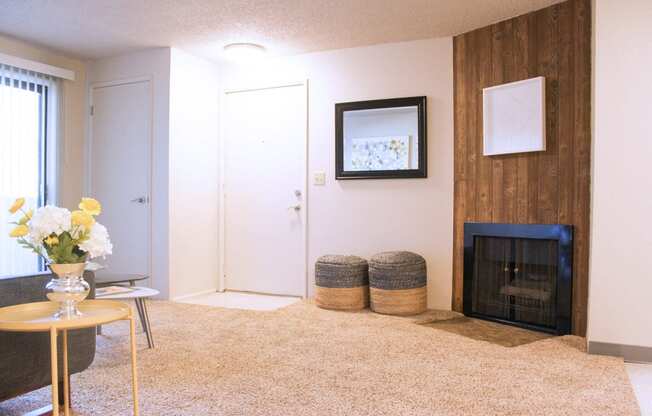 Carpeted living room with fireplace. Sliding doors to patio and staged with living room furniture.at The Lakes Apartments, Moses Lake