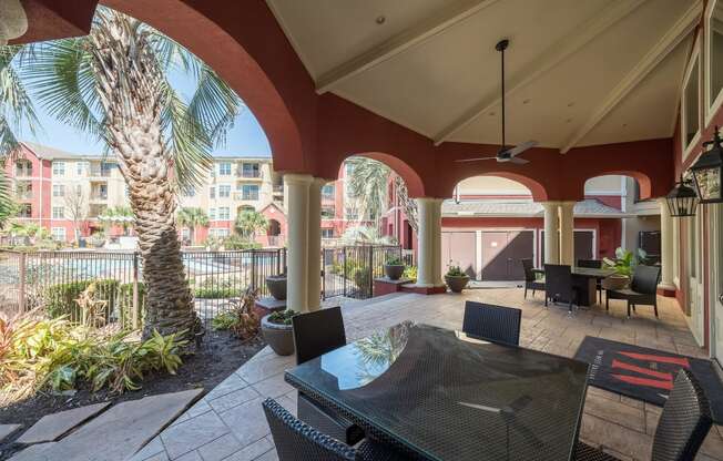 a patio with a table and chairs and a palm tree