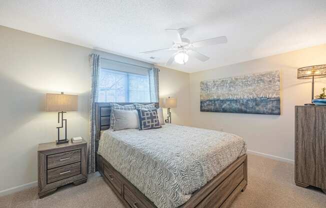 a bedroom with a bed and a ceiling fan