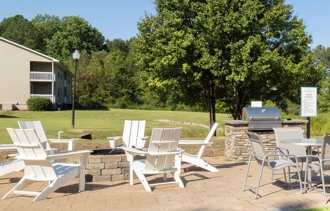 a patio with chairs and tables on a lawn