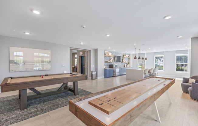 a game room with a shuffleboard table and a pool table