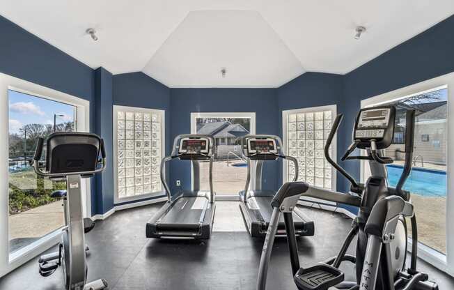 Two treadmills in a gym with windows and a pool  at Wellington Farms, Charlotte, North Carolina