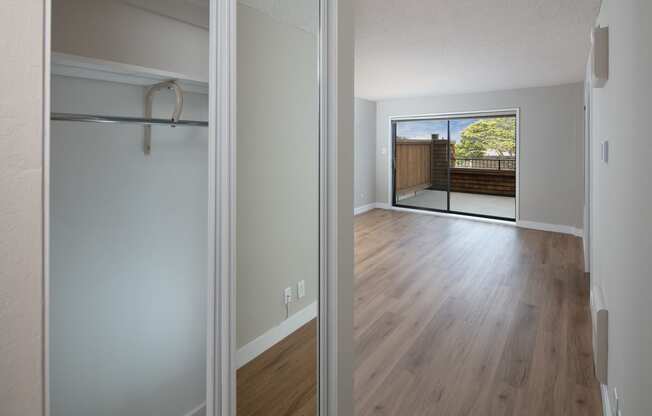 a bedroom with a large window and hardwood floors