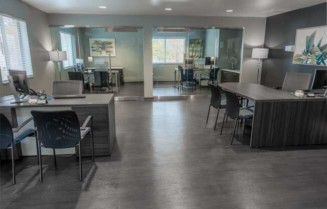 a conference room with desks and chairs and a table with chairs