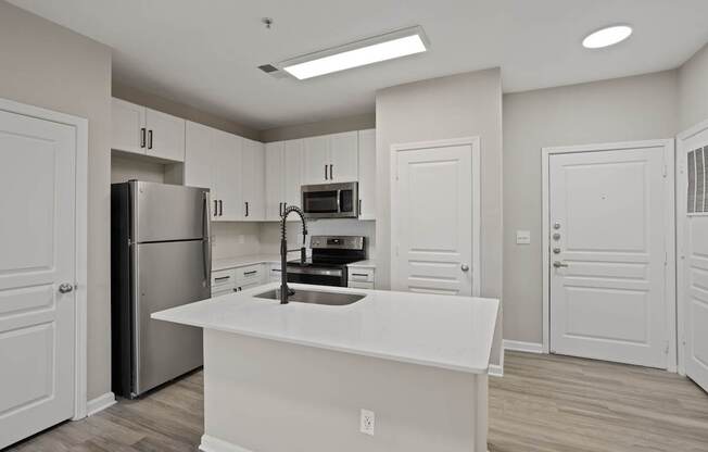 Flatiron West Trade Apartments unstaged model unit with quartz countertops, stainless steel appliances and a large living room.
