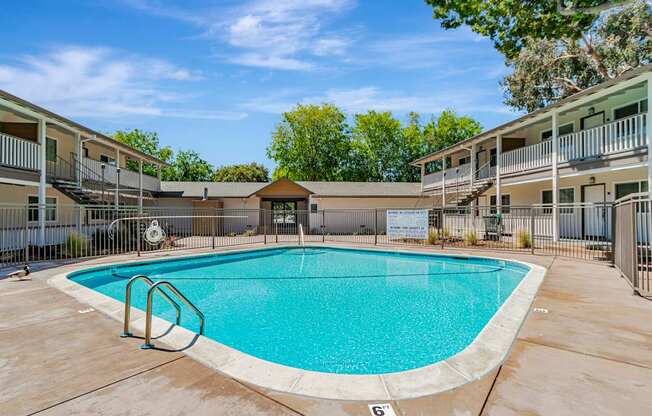 A swimming pool in a residential area surrounded by apartment buildings.