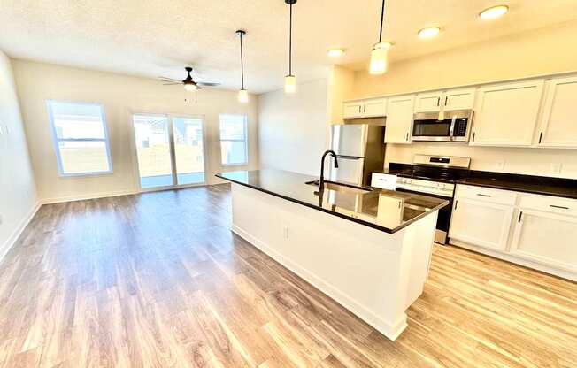 A kitchen with white cabinets and a black countertop.