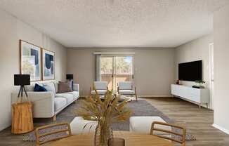 a living room with a couch chairs and a table with a vase of flowers on it