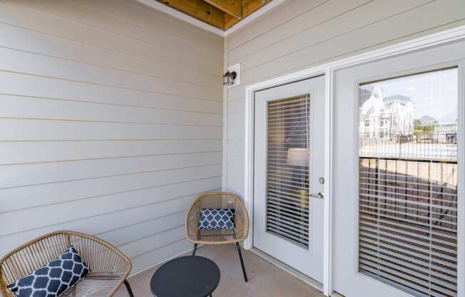 a small porch with two chairs and a door