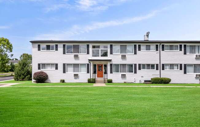 a white house with a green lawn in front of it