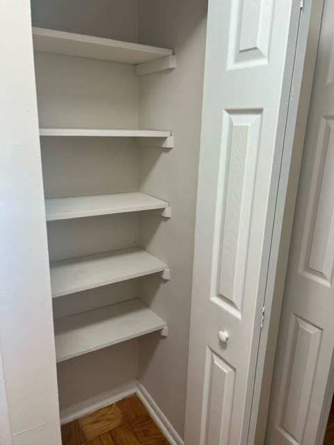 a white closet with white shelves and a white door