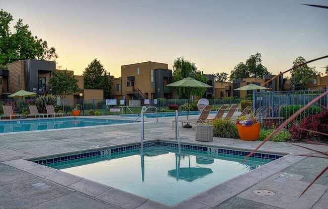 A swimming pool surrounded by a patio and a fence.